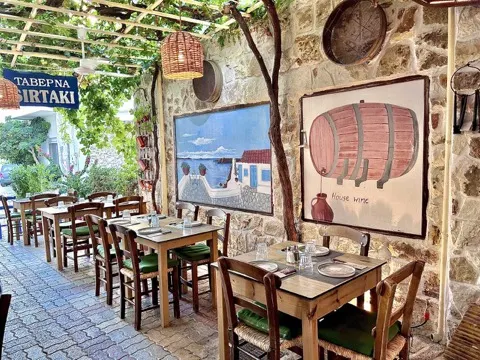 Back yard with stone wall and Greek wall paintings at Sirtaki Tavern