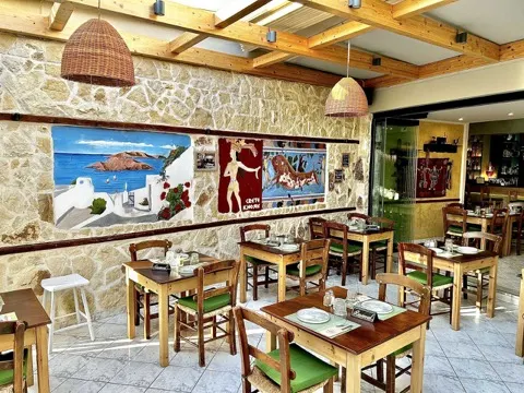 Front yard tables next to the stone wall at Sirtaki Tavern